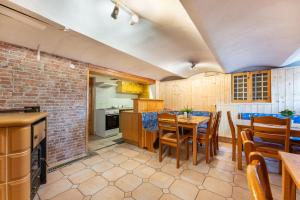 Una cocina y un comedor con mesa y sillas. en Penzion Polubný, en Kořenov