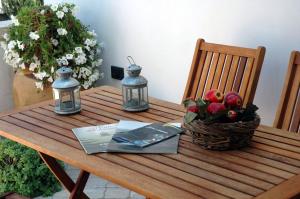 a wooden table with a basket of fruit and two lights at Antico Camino B&B in Muro Leccese