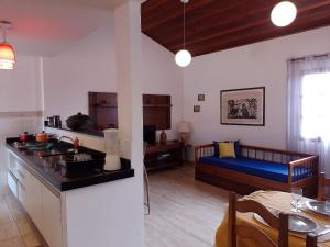kuchnia i salon z łóżkiem w pokoju w obiekcie PARAÍSO - ACONCHEGANTE - PRÁTICO E PRÓXIMO DE TUDO w mieście Cabo Frio