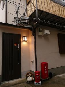 東山の宿 藤屋 في Giommachi: مبنى بباب اسود واضاءة بجواره