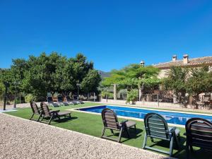 un grupo de sillas sentadas junto a una piscina en Apartamentos rurales La Alquería del Pilar, en Bañeres de Mariola