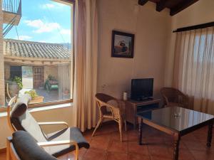 d'un salon avec une table, des chaises et une fenêtre. dans l'établissement Apartamentos rurales La Alquería del Pilar, à Banyeres de Mariola