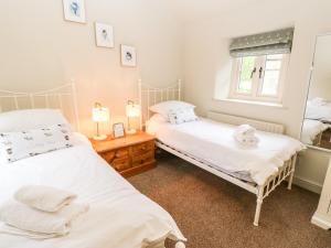 two twin beds in a room with a window at The Old Cobblers in Skipton