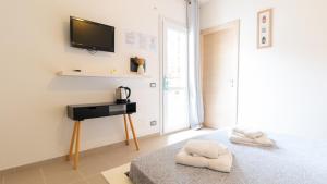 een slaapkamer met een bed en een televisie aan de muur bij Spapparra B&B in Càbras