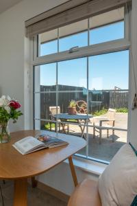 un soggiorno con tavolo e finestra in vetro di Furlong Cottage @ Higher Stancombe Farm a Kingsbridge
