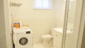 a bathroom with a washing machine and a toilet at Applewood Gardens Apartment in Mississauga +13 photos