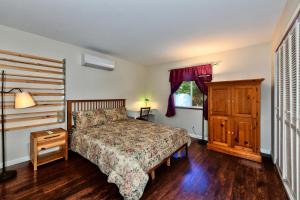 a bedroom with a bed and a dresser and a window at Bass Alley Bungalow Experience Wc Lodging in Lower Lake