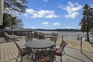 a table and chairs on a deck next to the water at Sandy Feet Retreat in Clearlake Oaks