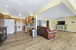 a living room with a couch and a kitchen at Sandy Feet Retreat -- Lakefront Retreat With Sand Volleyball Court! in Clearlake Oaks