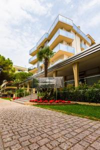 un edificio con una palmera delante de él en Hotel President, en Bibione