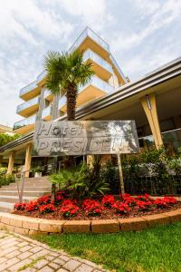 una señal frente a un edificio con una palmera en Hotel President en Bibione