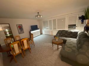 Apartament Regina في أوستكا: غرفة معيشة مع أريكة وطاولة وكراسي