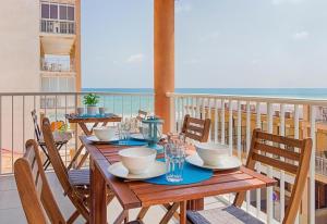 a table on a balcony with a view of the ocean at Seaview modern beach apartment in Guardamar del Segura