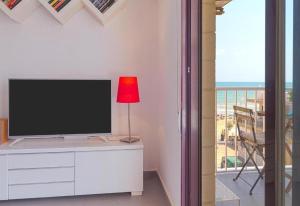 a living room with a television and a table with a lamp at Seaview modern beach apartment in Guardamar del Segura