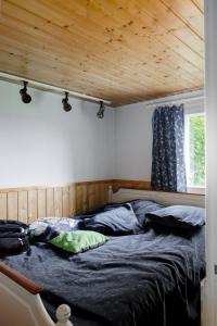 Mummon mökki - Granny´s cottage في Suonenjoki: سرير في غرفة ذات سقف خشبي