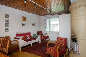 Cette chambre comprend un lit, des chaises et une cheminée. dans l'établissement Mummon mökki - Granny´s cottage, à Suonenjoki