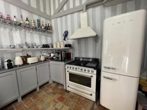 Il comprend une cuisine blanche équipée d'une cuisinière et d'un réfrigérateur. dans l'établissement Le Loft du Homard Bleu - entre Ciel et Mer - Free Parking 500m, à Honfleur