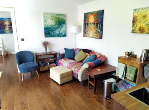 sala de estar con sofá y pinturas en la pared en The Gallery Lodges, en Braunton