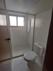 a white bathroom with a toilet and a window at Excelente Flat no Centro de Manaus próximo ao Teatro Amazonas. in Manaus