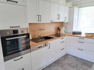 a white kitchen with white cabinets and a sink at Casa Ysermonde- Barkas 8 in Nieuwpoort
