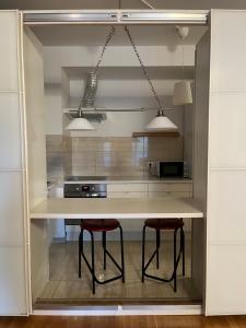 a kitchen with a counter with two stools in it at Apartament 2 camere Nordului in Bucharest