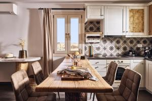 a kitchen with a wooden table and chairs at Kozadinos Art Suites in Kithnos
