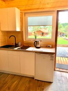 uma cozinha com um lavatório e uma janela em Ośrodek u Antosia na Mazurach em Narty