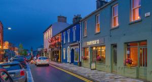 Une rue avec des voitures qui descendent dans une rue avec des bâtiments dans l'établissement Topper's Rooms Guest Accommodation, à Carrick-on-Shannon