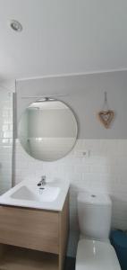 une salle de bain avec un lavabo, des toilettes et un miroir dans l'établissement Acollidor estudi amb encant nòrdic i amb parquing, al costat de Grandvalira, à Canillo 26 autres photos