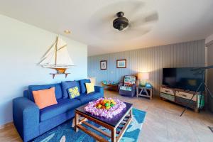 a living room with a blue couch and a tv at Pali Ke Kua 144 in Princeville
