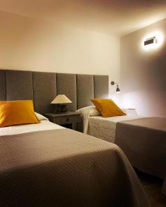 Habitación de hotel con 2 camas con almohadas amarillas en Le Dimore del Portico, en Fasano