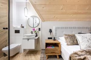 a bathroom with a bed and a sink and a mirror at VILLA TEDDY BEAR Zakopane in Zakopane