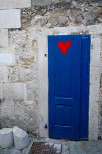 a blue door with a red heart on it at Old town Makarska apartments - central square in Makarska +29 photos