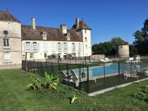 - un grand bâtiment avec une piscine en face dans l'établissement Château de la Berchère, à Nuits-Saint-Georges