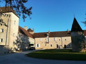 een groot bakstenen gebouw met een toren naast een straat bij Château de la Berchère in Nuits-Saint-Georges