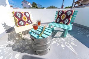 a table with two chairs and a barrel with two drinks at Boho House in Pakoštane