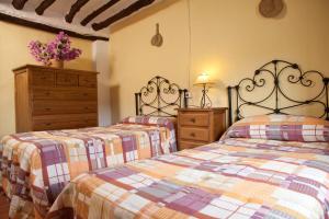 a bedroom with two beds and a dresser at vivienda turistica Fuente Zagrilla II in Zagrilla