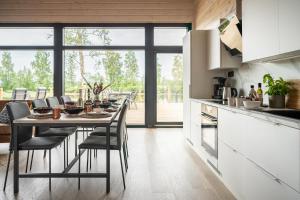 a kitchen with a table with chairs and a dining room at Villa Suisto in Pori