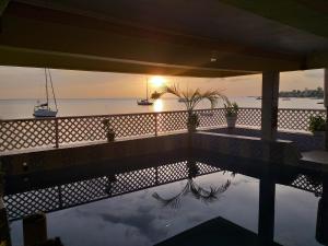 ein Pool mit Sonnenuntergang im Wasser in der Unterkunft Sea World Vacation Home in Roseau