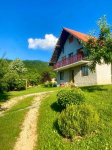 uma casa num campo verde com uma estrada de terra em Vikend kuća Ivković em Rudnik