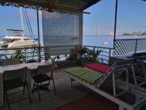 Un balcón con una cama, una mesa y un barco. en Sea World Vacation Home en Roseau