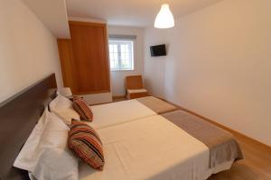a bedroom with a large bed in a room at Casa Cimo de Vila in Termas de Sao Pedro do Sul