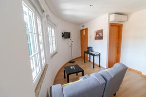 a living room with a couch and a table at Casa Cimo de Vila in Termas de Sao Pedro do Sul