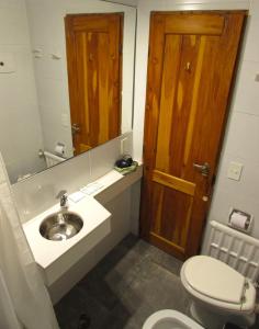 uma casa de banho com um lavatório, um WC e um espelho. em Hosteria Santa Rita em San Carlos de Bariloche