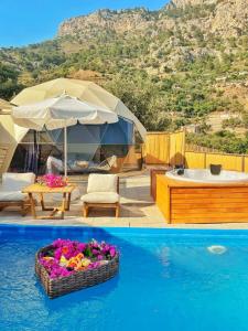 a villa with a swimming pool and a bath tub at Kabak Freedom Deluxe Hotel in Faralya