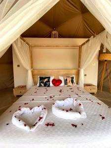 a bed with two pillows in the shape of hearts at Kabak Freedom Deluxe Hotel in Faralya
