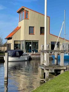 a boat is docked in front of a house at Boot & Huis Heeg in Heeg