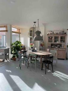 a dining room with a table and chairs in a kitchen at Boot & Huis Heeg in Heeg