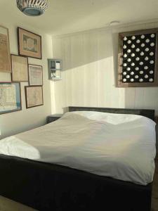 a white bed in a bedroom with a window at Boot & Huis Heeg in Heeg