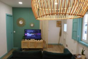 uma sala de estar com um sofá e um grande lustre em Casa dos Palecos na Nazaré